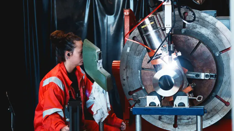 Dame i arbeidsklær bruker en teknisk maskin